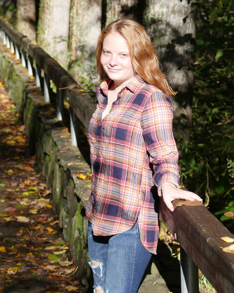 Kristina standing on a bridge in the forest